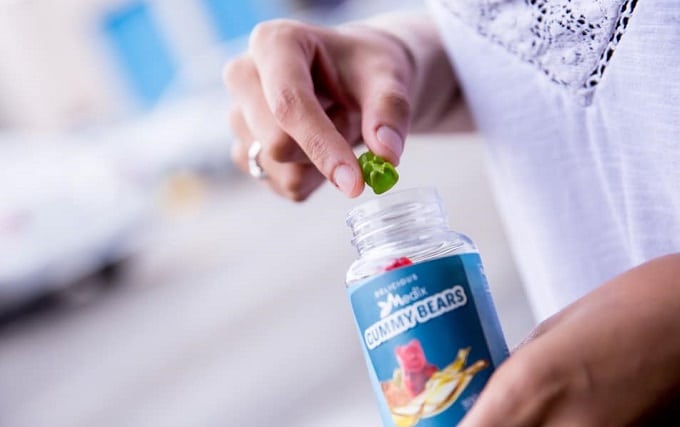 Sosteniendo una botella de gomitas de CBD
